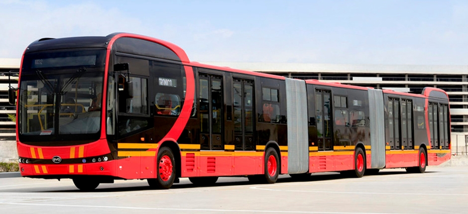 ônibus articulado a bateria estacionado e de cores vermelha com detalhes em amarelo e preto