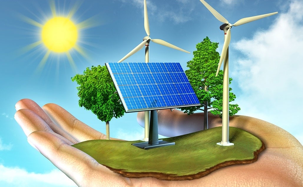 mão segurando um pequeno pedaço de terra com árvores, placa solar, aerogeradores e ao fundo um sol brilhante simbolizando a energia verde