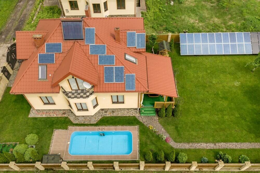 residência com diversas placas de energia solar que também são usadas para aquecer a piscina