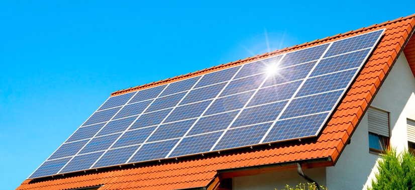 telhado de uma casa residencial com diversas placas solares instaladas e recebendo a luz do solar em um dia ensolarado