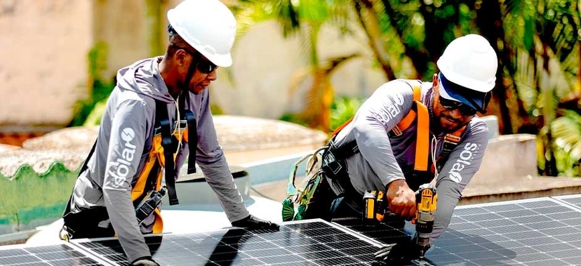 dois instaladores solar do Portal Solar realizando a instalação de painéis solares em uma residência