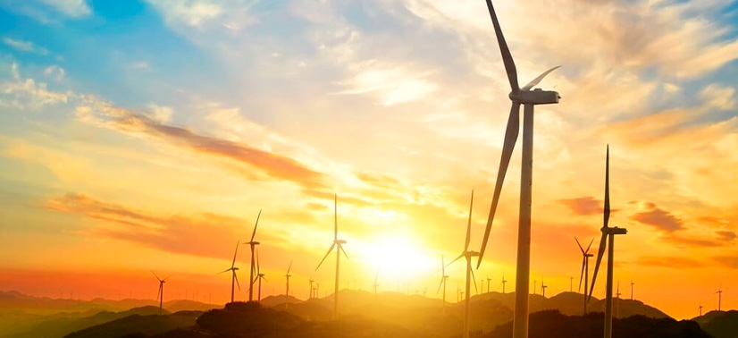 parque eólico ao pôr do sol com várias turbinas eólica gerando energia através do vento