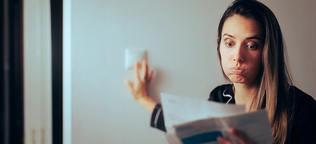 mulher desligando as lâmpadas de energia após ver o valor da conta de luz