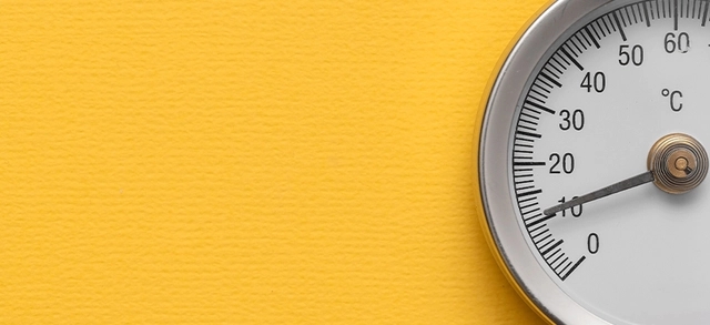 Termômetro indicando temperatura ambiente sobre fundo amarelo