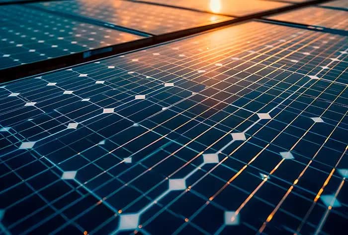 PAINÉIS SOLARES FOTOVOLTAICOS CAPTANDO LUZ DO SOL AO ENTARDECER, REPRESENTANDO A GERAÇÃO DE ENERGIA SOLAR