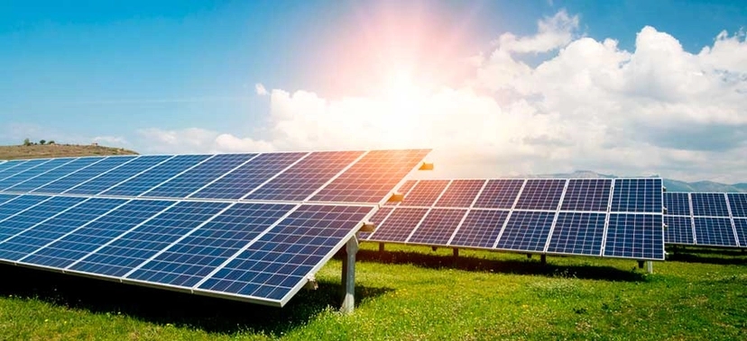 PLACAS SOLARES INSTALADAS EM CAMPO ABERTO COM CÉU AZUL E SOL BRILHANDO AO FUNDO