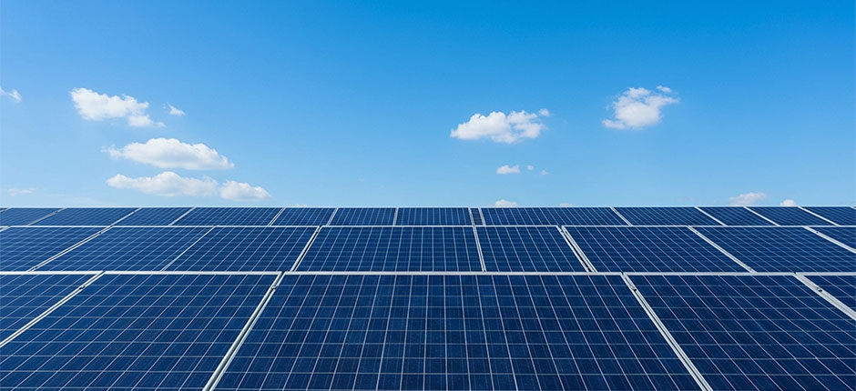 AINÉIS SOLARES FOTOVOLTAICOS INSTALADOS EM CAMPO ABERTO SOB UM CÉU AZUL COM POUCAS NUVENS.