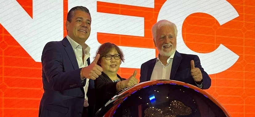 EXECUTIVOS EM FRENTE A UM PAINEL DE LED LARANJA