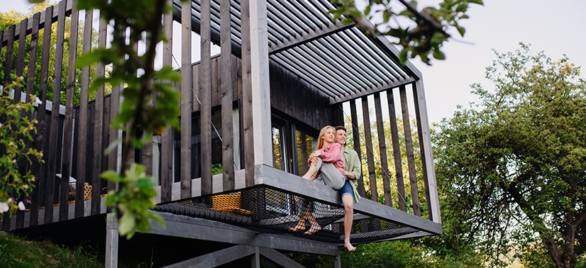 casa sustentável entre a vegetação com casal na varanda