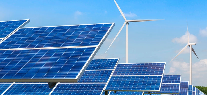 placas solares e ao fundo duas torres de energia eólica