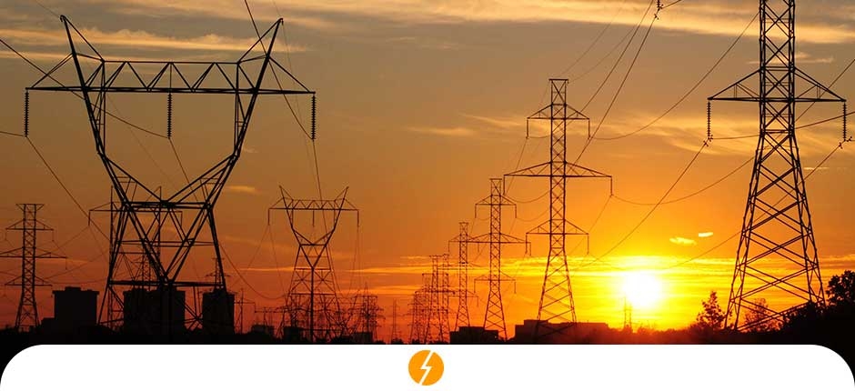 torres de energia elétrica e ao fundo um pôr do sol