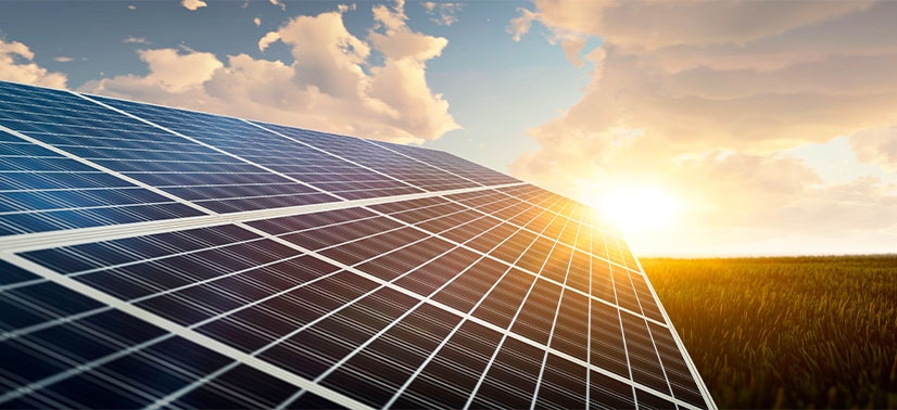 campo com painéis solares captando a luz do sol. O cenário inclui um céu parcialmente nublado com o sol brilhando ao fundo, iluminando os painéis solares.