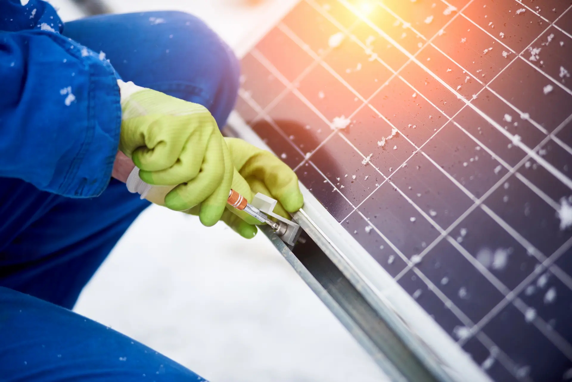 mão de uma pessoa realizando a manutenção de uma placa de energia solar fotovoltaica