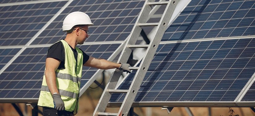 Homem realizando a instalação de painel solar seguindo ao menos uma norma técnica para instalação de energia solar